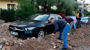 Жители Ано-Глифады откапывают машины из грязи кирками и лопатами